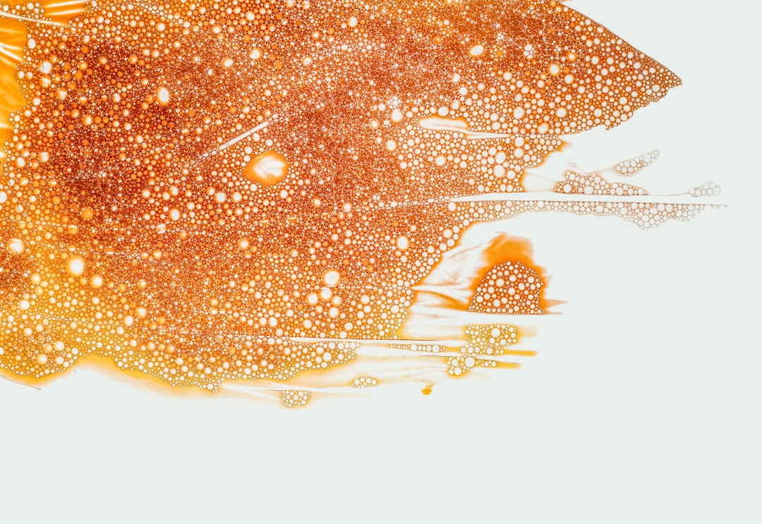 Close-up of vibrant orange bubbles resembling cellular structures, highlighting salmon DNA's potential benefits for skin health.